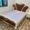 Chiếm Vị Trí Trung Tâm Trong Bộ Giường Tủ Phòng Ngủ Tân Cổ Điển Là Chiếc Giường Hoa Quỳnh Bọc Da Màu Nâu Cà Phê