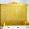 Chiếc tủ trong combo giường tủ tân cổ điển được phun màu vàng chanh, chất liệu gỗ công nghiệp mdf, tủ có 6 cánh, 2 ngăn kéo, có kệ góc trang trí bên trái, kích thước 2m8x2m3